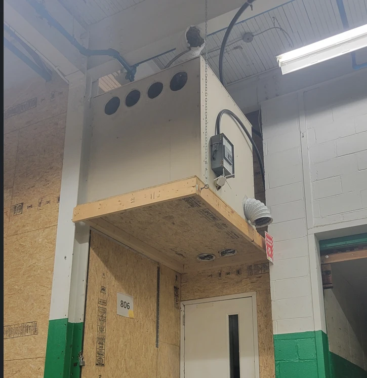 Unité de chauffage HeatSync de 17 kW sur une plateforme au-dessus d'une porte, à l'entrepôt, avec son wattmètre